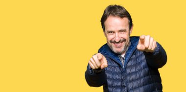 Orta yaş yakışıklı adam giyen kış sen ve kameraya gülümseyen pozitif ve neşeli parmaklarıyla işaret kat