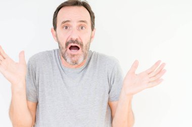 Üst düzey yakışıklı üzerinde izole arka plan clueless ve şaşkın bir ifadeyle kollar ve eller kaldırdı. Şüphe kavramı.