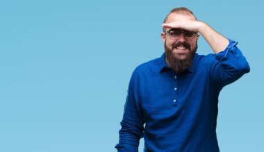 Üzerinde gözlük takan Genç beyaz hipster adam arka plan çok mutlu ve gülümseyen uzakta el ile üzerine kafa seyir izole. Arama kavramı.