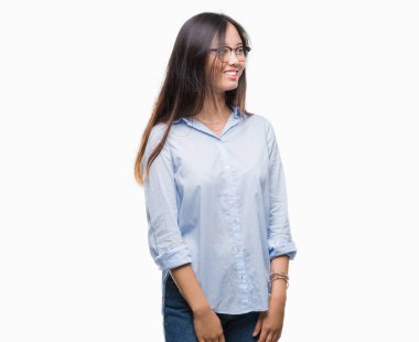 Arka plan uzak tarafına gülümseme ile yüzünde, doğal ifade seyir üzerinde gözlük takan genç Asya iş kadını izole. Kendine güvenen gülüyor.