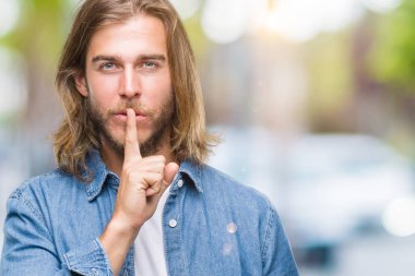 Young handsome man with long hair over isolated background asking to be quiet with finger on lips. Silence and secret concept. clipart
