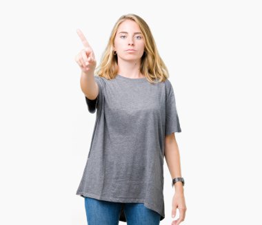 Büyük boy rahat t-shirt üzerinde izole giyen güzel genç kadın arka plan işaret parmağını ve kızgın ifade ile