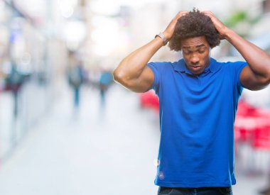 Afro Amerikalı adam çünkü umutsuz ve stresli baş ağrısı acı izole arka plan üzerinde ağrı ve migren. Ellerini kafasına.