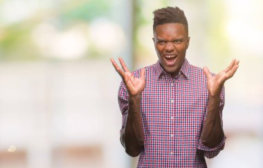 Afrikalı-Amerikalı genç deli kutluyor ve silah ile başarı için heyecanlı çığlık kaldırdı ve açık gözleri hayret izole arka plan üzerinde. Kazanan kavramı