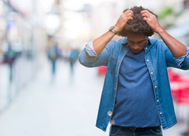 Afro Amerikalı adam çünkü umutsuz ve stresli baş ağrısı acı izole arka plan üzerinde ağrı ve migren. Ellerini kafasına.