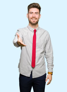 Tebrik ve konuksever dost sunan karşılıklı gülümseyen genç yakışıklı iş adamı. Başarılı iş.