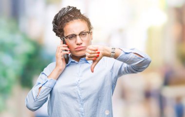 Genç örgülü saç Afro-Amerikan iş kız gösteren arama smartphone kızgın yüzü, eksi işareti aşağı antipati başparmak ile gösterilen, ret kavramı ile izole arka plan üzerinde kullanma