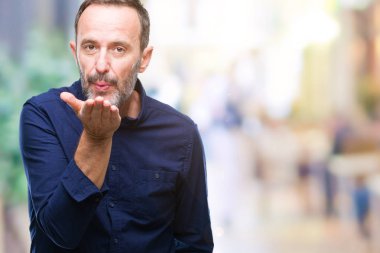 Orta yaş bir öpücük el ile güzel ve seksi olmak hava üfleme kamera bakarak izole arka plan üzerinde ağarmış komuta sizde. Aşk ifade.