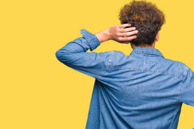 Denim ceket geriye düşünme hakkında şüphe el ile kafasına takmış afro saçlı Genç yakışıklı adam