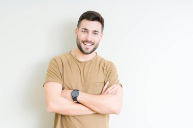 İzole arka plan mutlu yüz çapraz silah kameraya bakarak ile gülümseyen genç yakışıklı adam. Olumlu bir kişi.