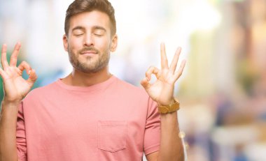 Yakışıklı delikanlı izole arka plan üzerinde dinlenmek ve gülümseyen gözlerle parmak ile meditasyon jest yapıyor kapalı. Yoga kavramı.