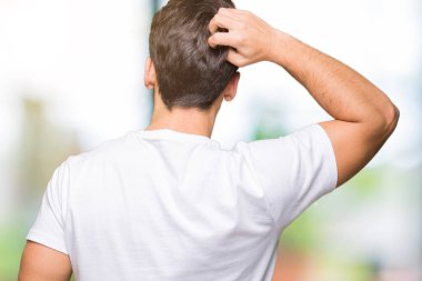 İzole arka plan geriye düşünme hakkında şüphe kafasına el ile üzerine beyaz t-shirt giyen genç yakışıklı adam