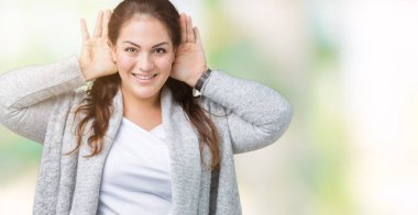 Artı boyutu genç kadın güzel kulak jest, dedikodu için meraklı üstünde her ikisi de dinliyoruz izole arka plan üzerinde giyen kış ceket eller. İşitme sorunu, sağır