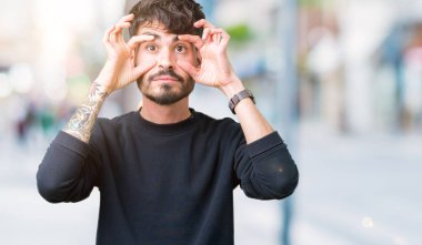 Yakışıklı delikanlı ile parmak, Uykulu ve sabah yorgunluk için yorgun gözlerini açmaya çalışırken izole arka plan üzerinde