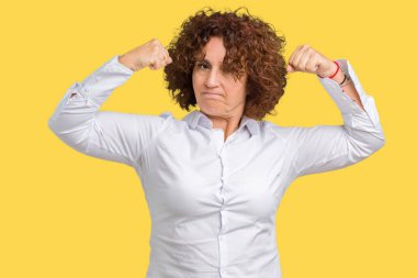 Güzel orta ager üst düzey businees kadın kol kasları gururlu gülümseyen gösterilen izole arka plan yüzünden. Fitness kavramı.