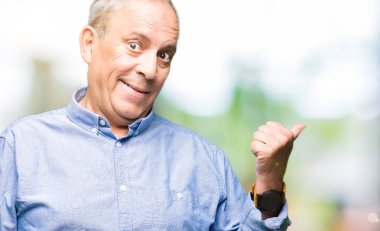 Şık gömlek arıyorsunuz ve başparmak yanında yukarıyı mutlu yüz ile gülümseyen yakışıklı üst düzey businesss adam.