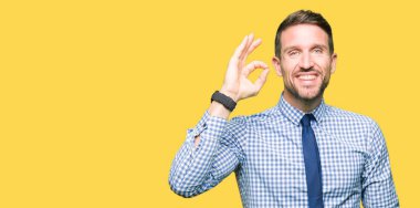 Yakışıklı iş adamı giyen kravat el ve parmaklar ok işaretiyle yapıyor olumlu gülümseyerek. Başarılı ifade.