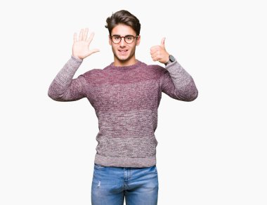 Gösterilen arka plan üzerinde gözlük takan genç yakışıklı adam izole ve parmakları ile işaret kendinden emin ve mutlu gülümseyerek süre 6 numara.