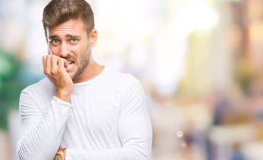 Genç yakışıklı adam stresli ve gergin ile izole arka plan üzerinde tırnak ısırma dudaklarından eller. Anksiyete sorunu.