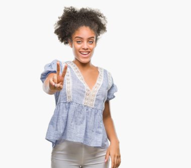 Zafer işareti yapıyor parmak gösterilen kamera seyir gülümseyen izole arka plan üzerinde genç afro Amerikalı kadın. İki numaralı.