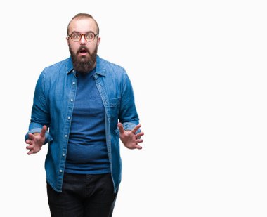 Üzerinde gözlük takan Genç beyaz hipster adam arka plan korkuyor ve şok sürpriz ifade, korku ve heyecan yüz ile izole.