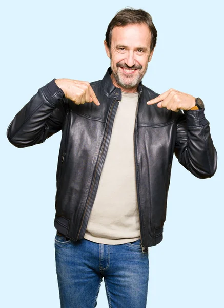 Orta yaş yakışıklı adam yüzünde gülümseme ile kendinden emin görünüyorsun, kendini gururlu ve mutlu parmakları ile işaret siyah deri ceket.