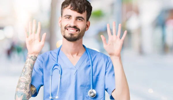 잘생긴 간호사 배경에 보여주는 유니폼을 남자와 손가락으로 가리키는 자신감과 — 스톡 사진