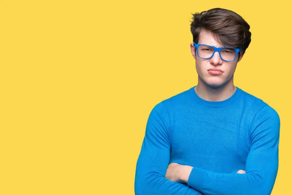 年轻英俊的男人戴着蓝色的眼镜 对孤立的背景持怀疑态度和紧张 不赞成的表情在脸上交叉的手臂 消极的人 — 图库照片