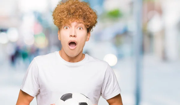 驚き顔 恐怖表現と興奮とショックで怖いサッカー サッカー ボールを保持している若いハンサムな男 — ストック写真
