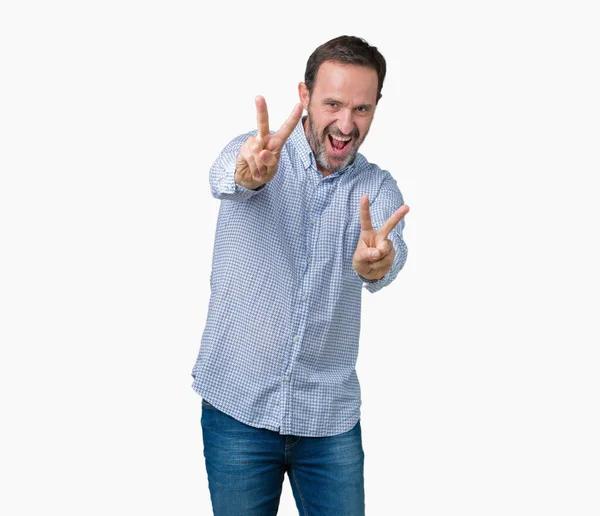 ハンサムな中年勝利のサインをやって指を表示するカメラを笑みを浮かべて孤立の背景上のエレガントな年配の男性 — ストック写真