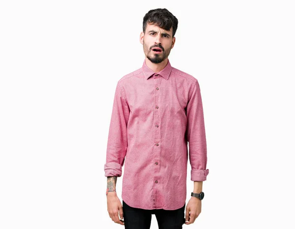 懐疑的 皮肉を探してショック顔に孤立した背景にピンクのシャツを着て若いハンサムな男が口を開けてびっくり — ストック写真