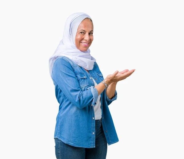 中世纪阿拉伯东部妇女戴着阿拉伯头巾在孤立的背景指向一边 手和开放的手掌 提出广告微笑快乐和自信 — 图库照片