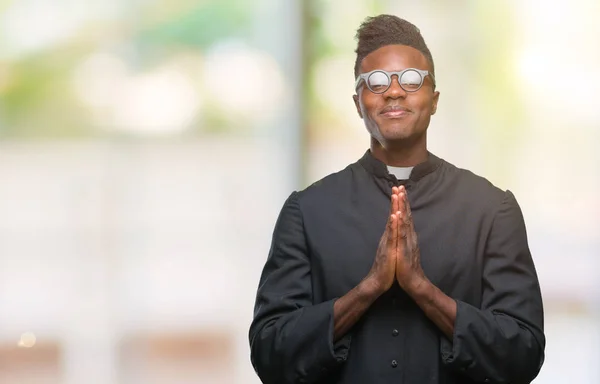 年轻的非洲裔美国牧师在孤立的背景祈祷与手一起请求宽恕微笑自信 — 图库照片