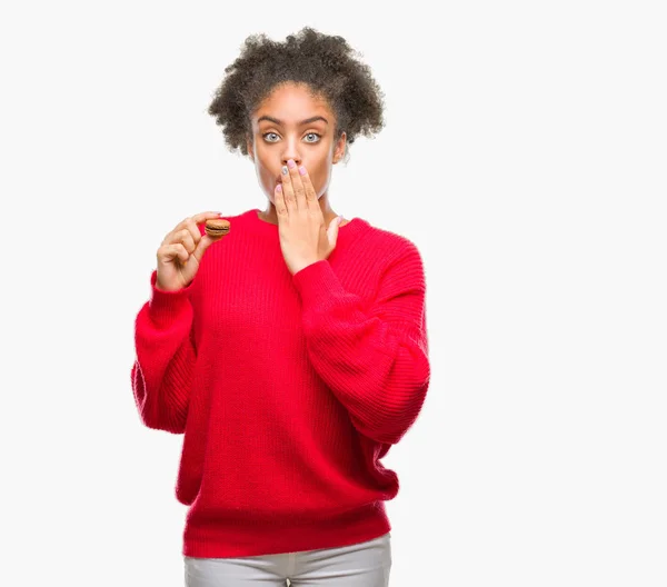 Joven Afroamericana Comiendo Chocolate Macaron Sobre Fondo Aislado Cubrir Boca — Foto de Stock