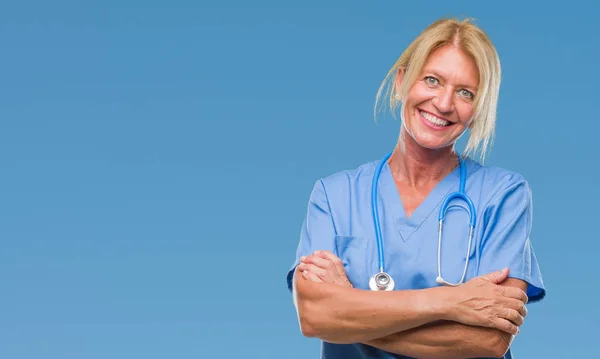 中年金髪看護師外科医医師女性組んだ腕のカメラを見て笑みを浮かべて分離背景幸せ顔に 肯定的な人 — ストック写真