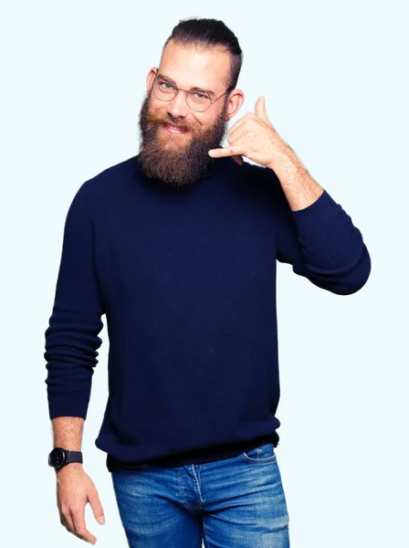 眼鏡とタートルネックのセーターのことを笑っている若い金髪の男の手と電話で話しているように指でジェスチャーを電話 通信の概念 — ストック写真