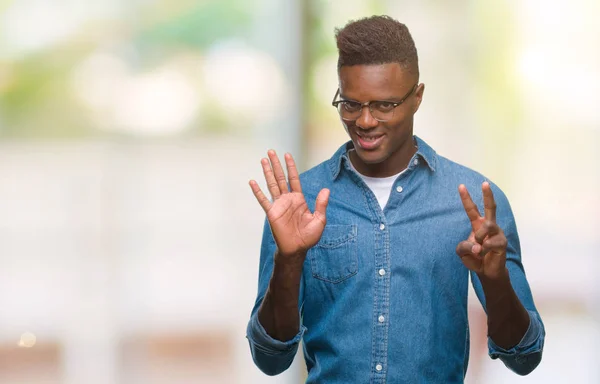 年轻的非洲裔美国人在孤立的背景显示和指向手指数七 而微笑着自信和快乐 — 图库照片