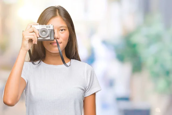 年轻的亚洲妇女持有 Vintagera 照片相机在孤立的背景下 一个自信的表情 聪明的面孔认真思考 — 图库照片