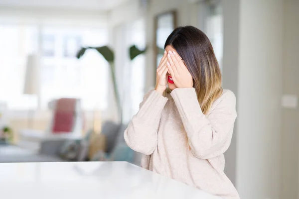 年轻美丽的女人穿着冬天的毛衣在家里与悲伤的表情覆盖着脸与手 而哭泣 抑郁症的概念 — 图库照片
