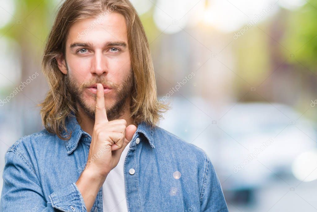 Young handsome man with long hair over isolated background asking to be quiet with finger on lips. Silence and secret concept.