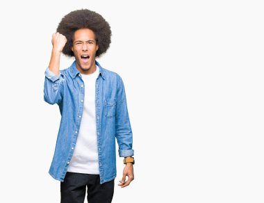 Afrikalı-Amerikalı genç afro saçlı öfkeli ve sinirli sinirli ve öfke ile bağırarak süre öfkeli yumruk yükselterek. Öfke ve agresif kavramı.