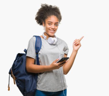 Sırt çantası izole arka plan üzerinde çok mutlu el ve parmak ile tarafına işaret tutan genç güzel afro Amerikan öğrenci kadın