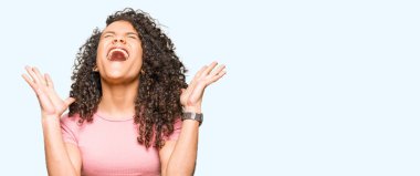 Kızgın ve silah ile başarı için deli kutlayan pembe t-shirt giyen kıvırcık saçlı Genç güzel kadın kaldırdı ve heyecanlı çığlık gözler kapalı. Kazanan kavramı