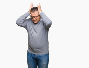 Orta yaş bussines Arap adam gözlüklü çünkü umutsuz ve stresli baş ağrısı acı izole arka plan üzerinde ağrı ve migren. Ellerini kafasına.