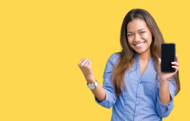 Genç güzel esmer iş kadın gösteren ekran smartphone gurur çığlık ve zafer ve başarı çok heyecanlı, duygu tezahürat kutluyor izole arka plan üzerinde