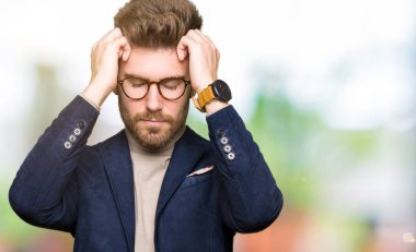 Genç yakışıklı iş adamı gözlük çünkü umutsuz ve stresli baş ağrısı acı acı ve migren. Ellerini kafasına.