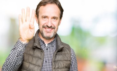 Kış yelek gösterme ve parmakları ile işaret giyen orta yaş yakışıklı adam kendinden emin ve mutlu gülümseyerek süre dört numara.