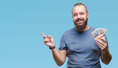 Genç hipster adam holding grup izole arka tarafına el ve parmak ile işaret çok mutlu para