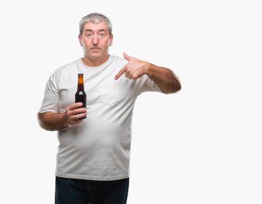 Üst düzey yakışıklı sürpriz yüz işaret parmağı kendini izole arka plan üzerinde bira şişesi içme