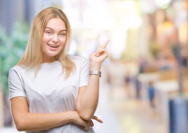 Kameraya bakarak yan el ve parmak ile işaret izole arka yüzünde kocaman bir gülümseme ile genç beyaz kadın.